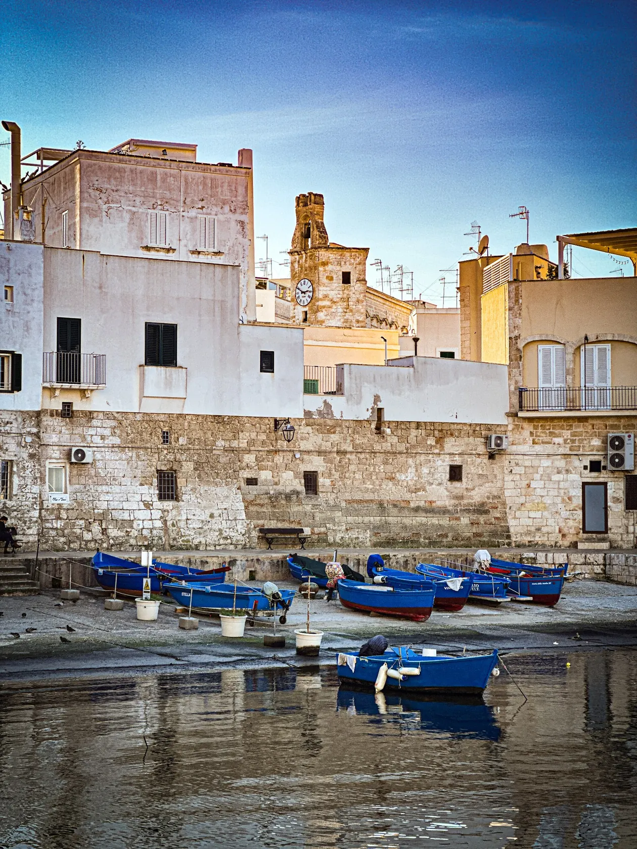 Porto Vecchio w Monopoli: niebieskie łodzie rybackie i zabytkowa zabudowa nad wodą