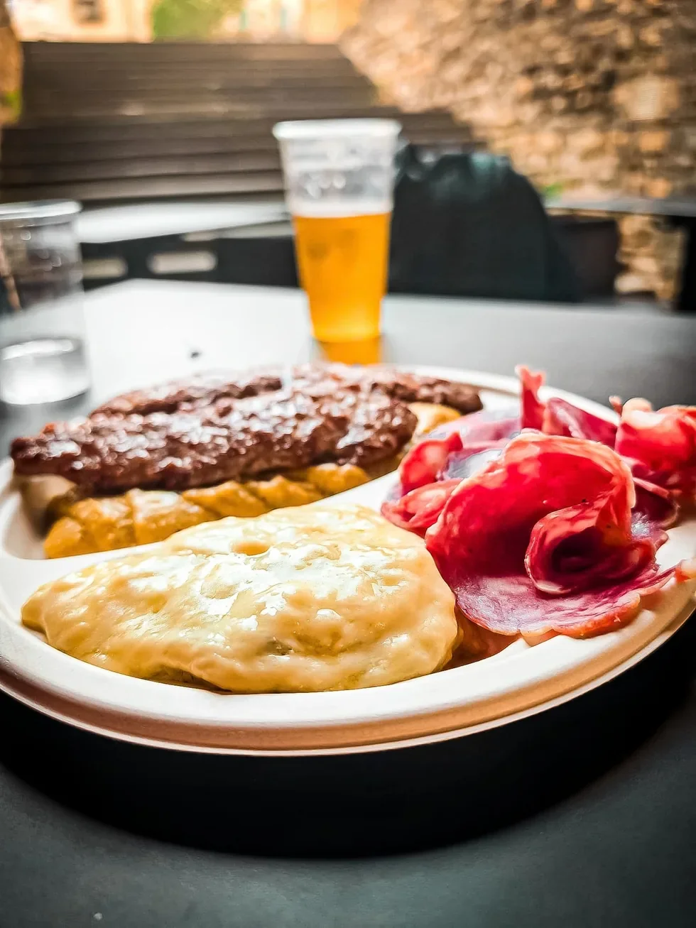 Polenta na talerzu z serem, mięsem i plasterkami regionalnych wędlin w Bergamo